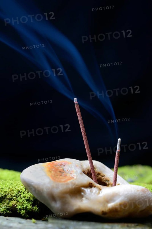 Burning incense sticks stuck in stone