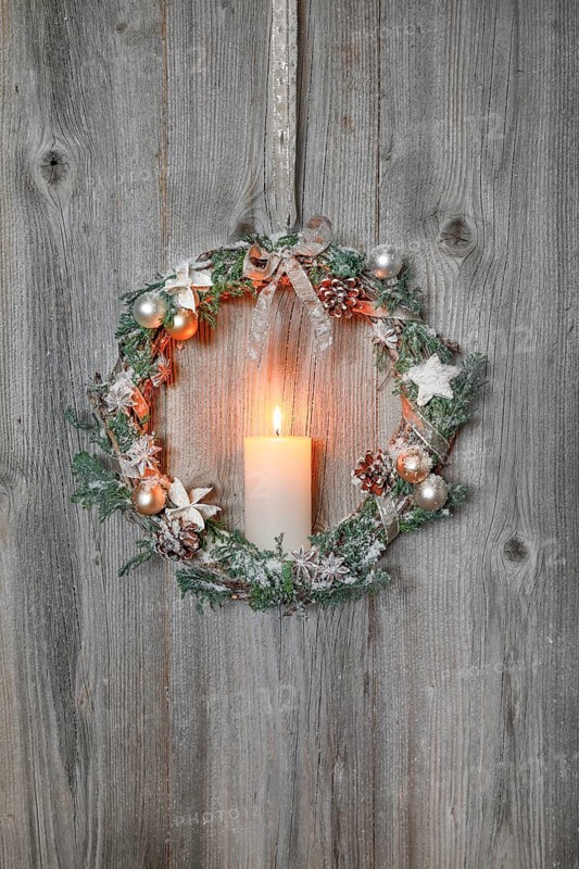 Christmas wreath on wooden wall with candle