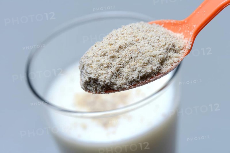 Tigernut flour in spoon and glass of milk