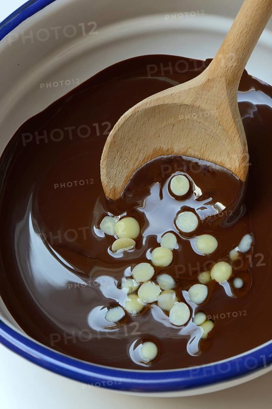 Liquid chocolate coating and melting cocoa butter with spoon