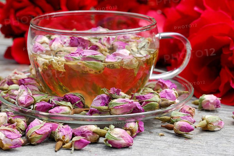Rose tea in cup and rose buds