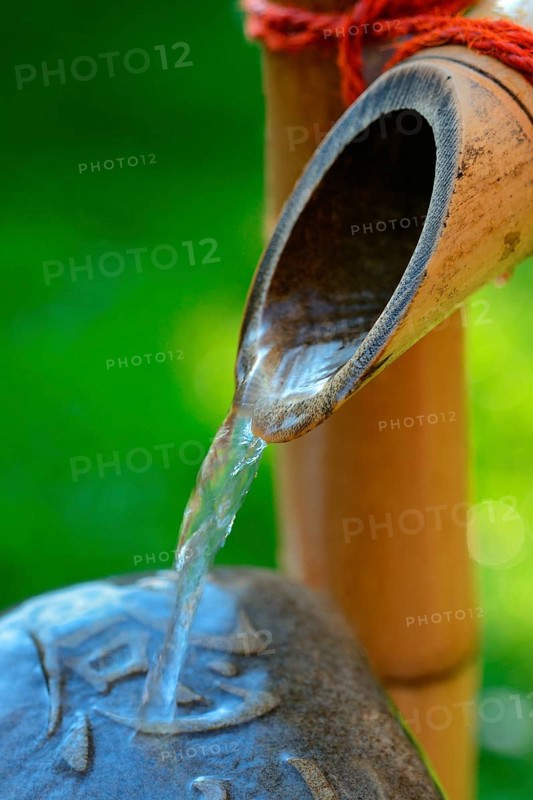 Japanese bamboo fountain and stone with inscription