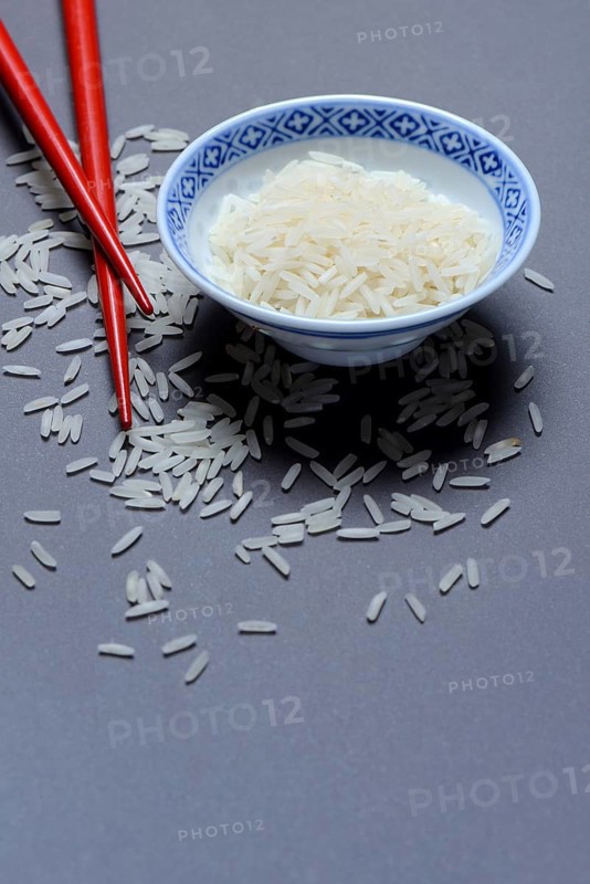 Rice grains in husk and chopsticks