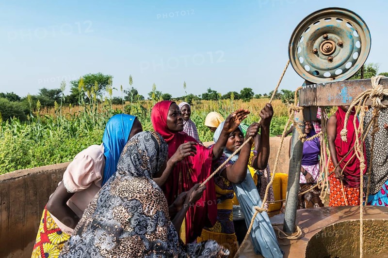 Colourful dressed women fetch water at the well