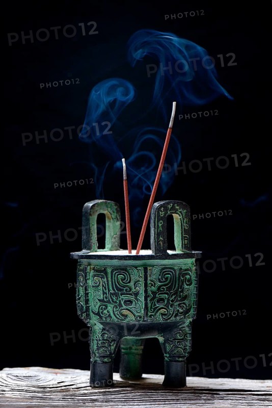Incense burner with burning incense sticks