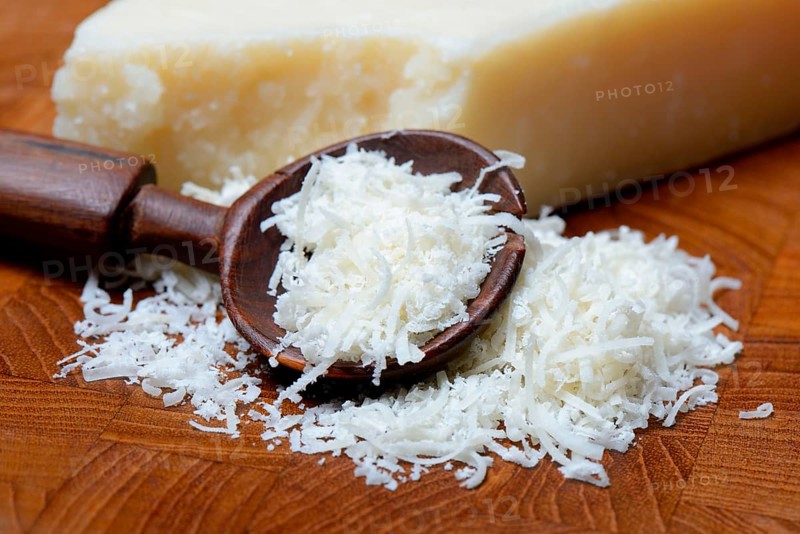 Grated Parmesan cheese and piece of Parmesan cheese