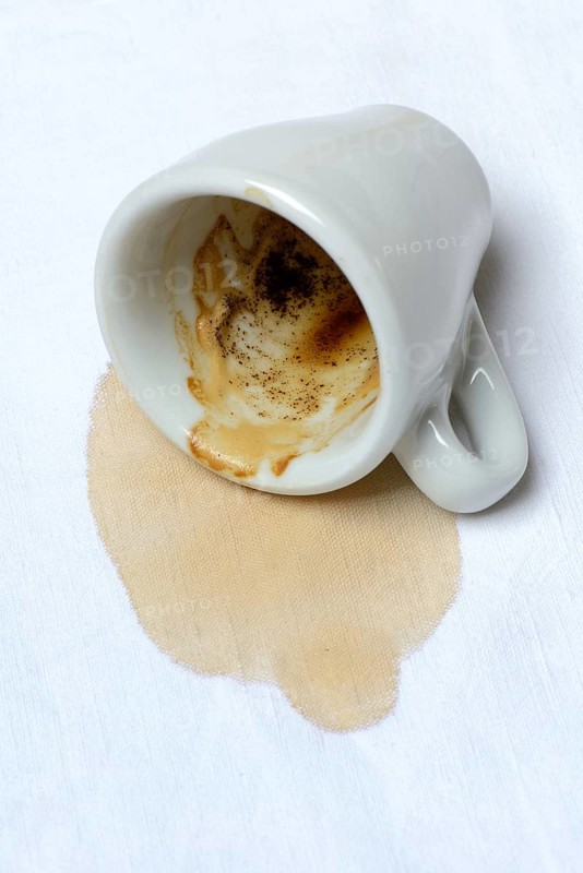 Coffee stain on tablecloth and fallen cup