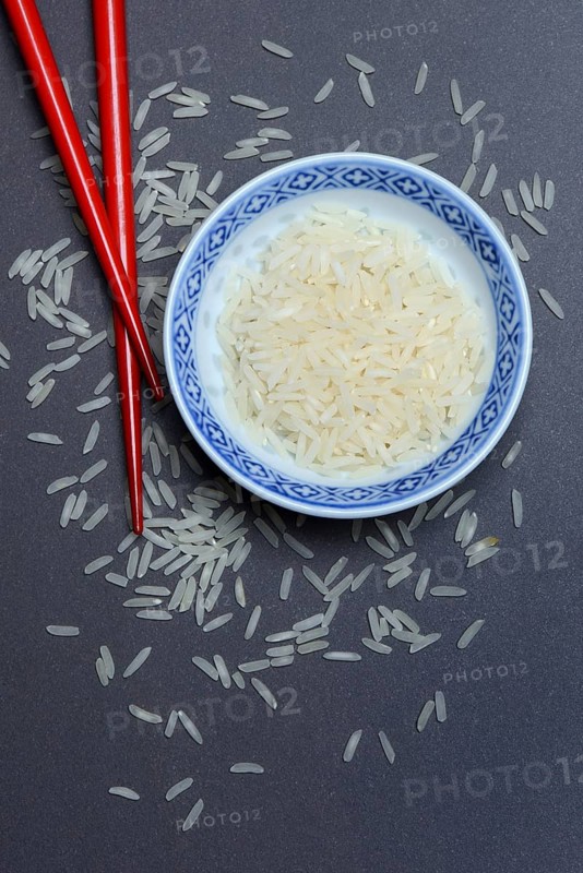 Rice grains in husk and chopsticks
