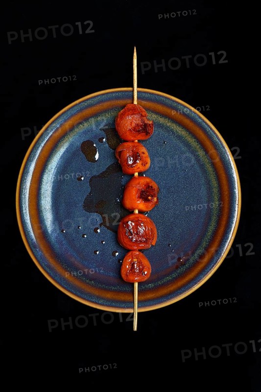 Roasted cherry tomatoes on skewer on plate