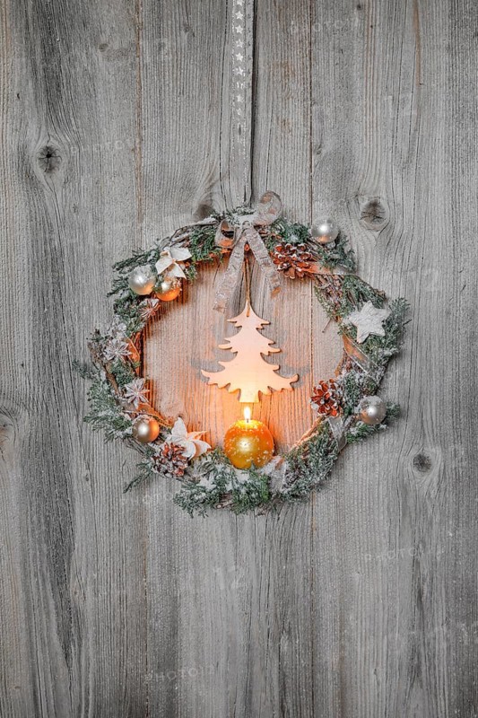 Christmas wreath on wooden wall with candle