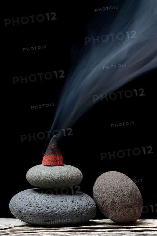 Burning incense cone on stones