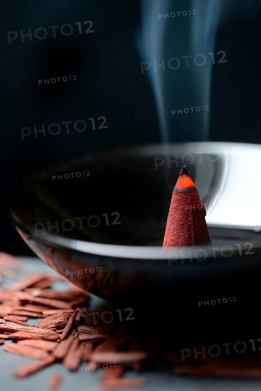 Burning incense cone and sandalwood