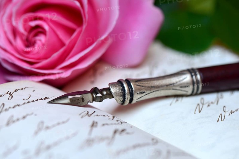 Pen and pencil with nib on book with old handwriting