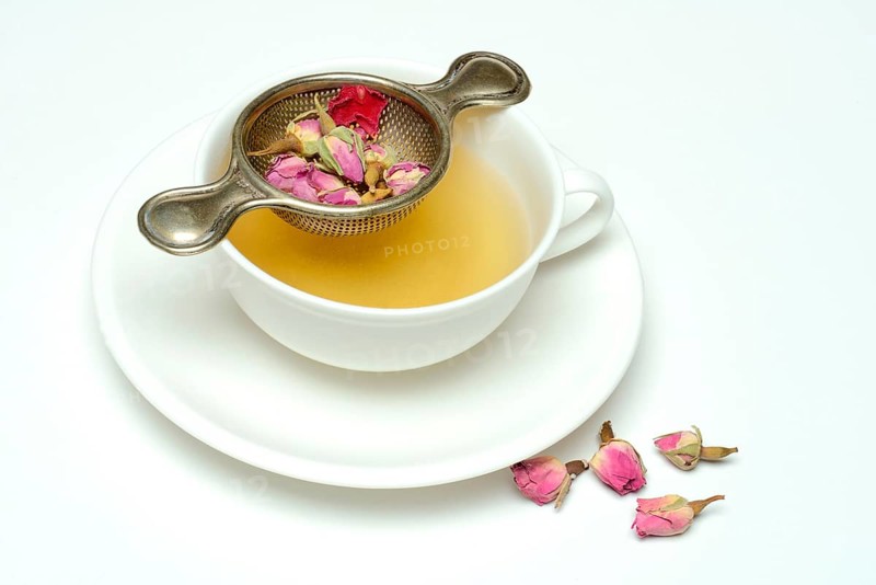 Rose tea in cup and rose buds