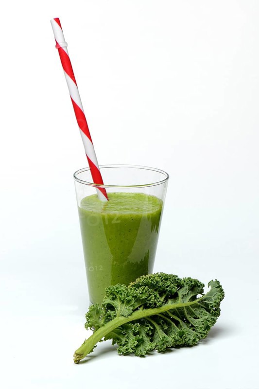 Kale smoothie in glass with drinking straw