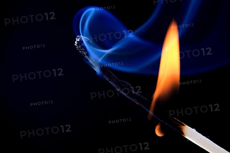 Burning match forms blue smoke