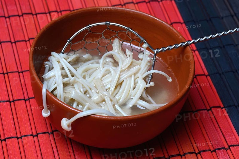 Boiled Golden needle mushroommushrooms in bowl with strainer