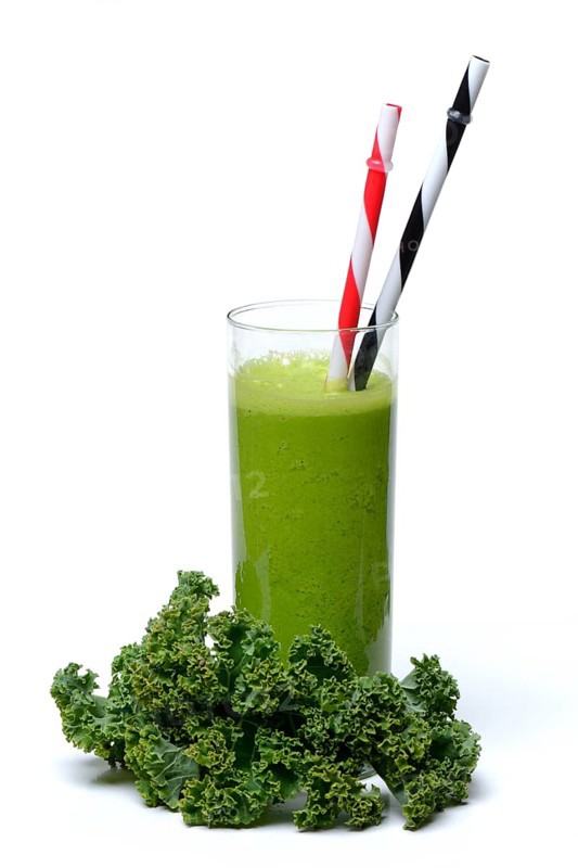 Kale smoothie in glass with drinking straw