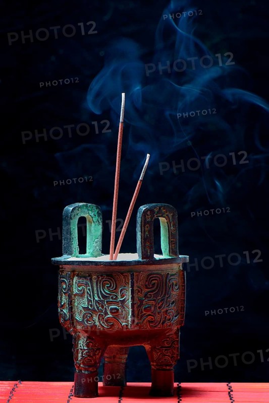 Incense burner with burning incense sticks