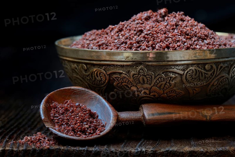 Sumac powder in bowl and spoon