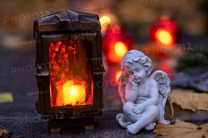 Burning grave light and angel figure on a grave