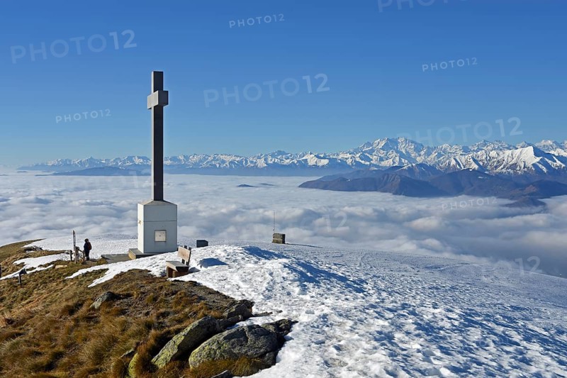 Summit cross of Monte Lema and sea of clouds over Lake Maggiore