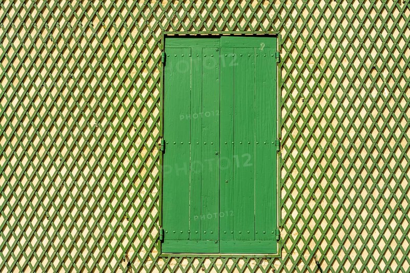 Green window on a wooden lattice wall
