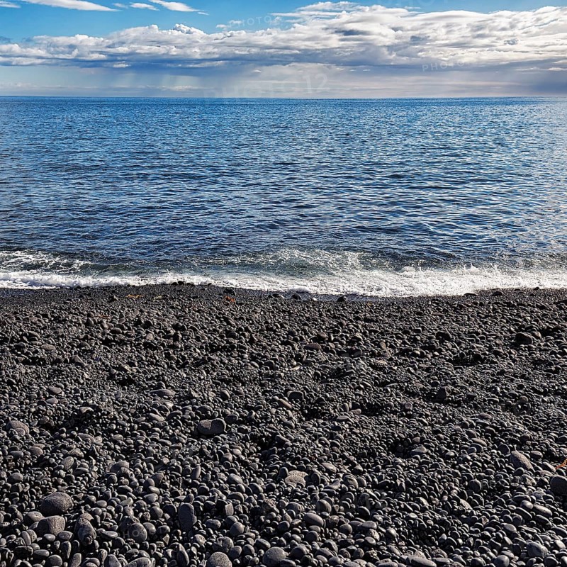 Black stones rounded by the sea