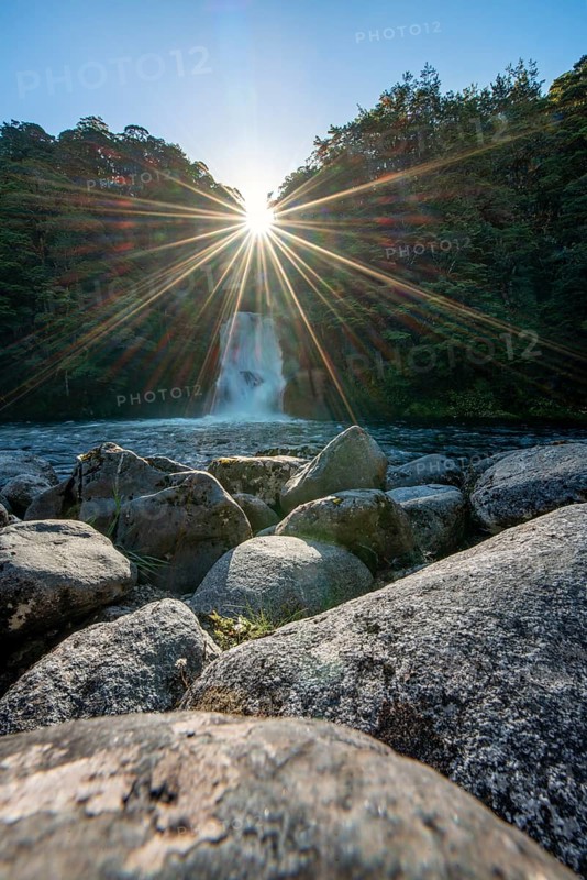 Waterfall in forest with sunbeams