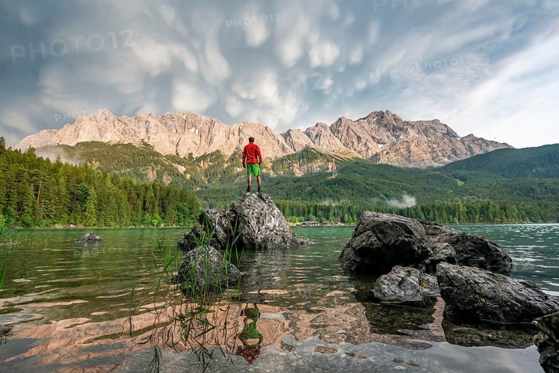 Young man standing on a rock on the shore