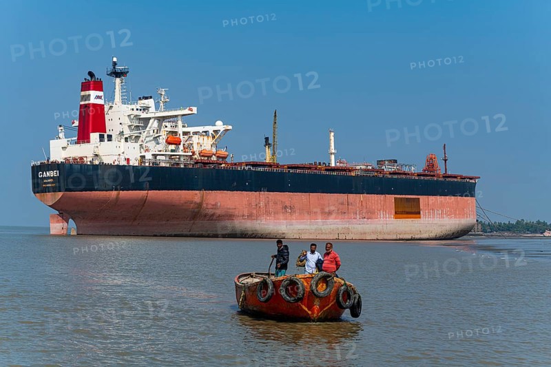 Little boat under a Huge container ship ready to break up