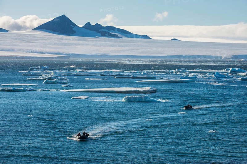 Zodiac with tourists cruising through the icebergs