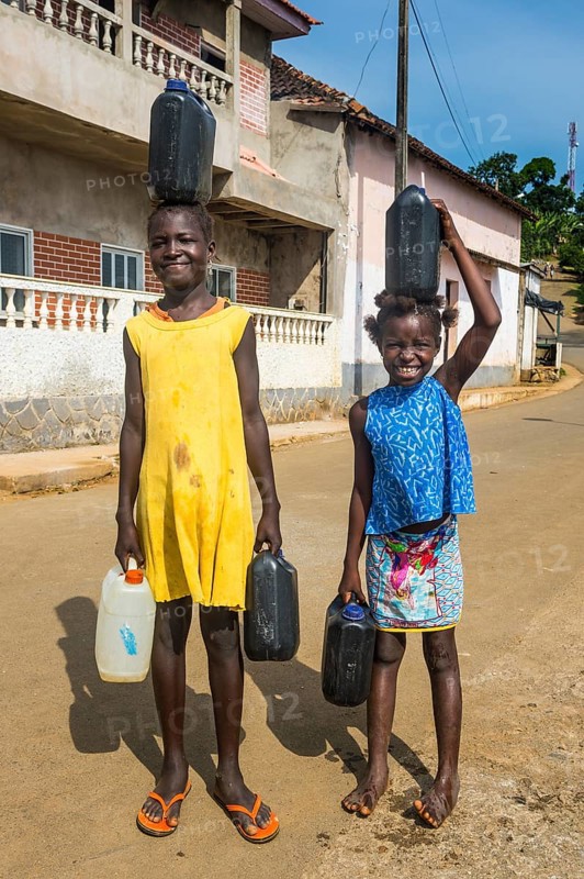 Friendly girls carrying a water canister