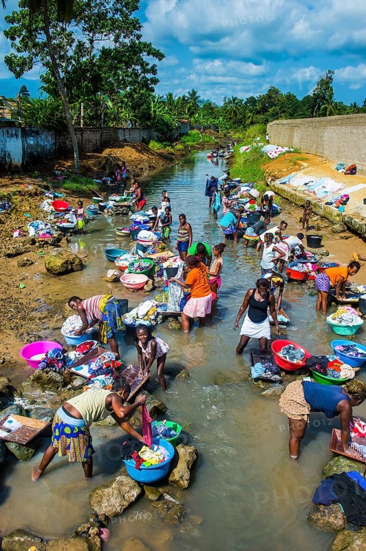 Women washing clothes in a river bed