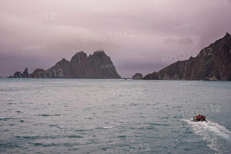 Zodiac with divers on its way to the rugged shore of Elephant island
