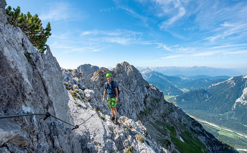 Mountaineer climbs on a secured fixed rope route
