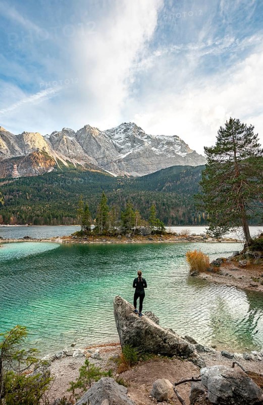 Young woman standing on a rock on the shore