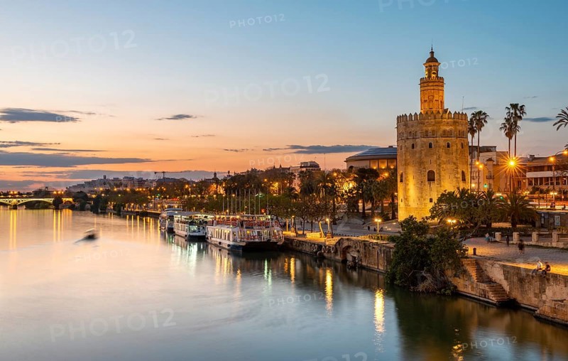 View over the river Rio Guadalquivir with Torre del Oro and promenade with excursion boats