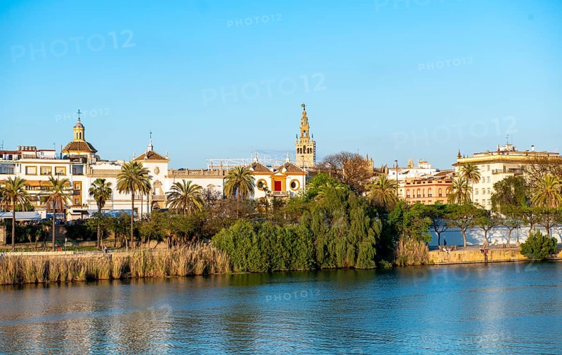 View over the river Rio Guadalquivir to the bullring Plaza de toros de la Real Maestranza de Caballeria de Sevilla and bell tower La Giralda