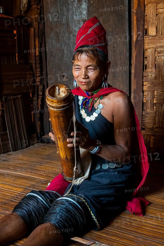 Old Kayah woman playing local instrument