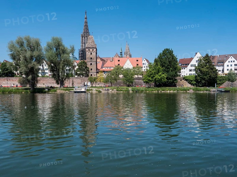 Ulm Cathedral and buildings on the banks of the Danube with water reflection
