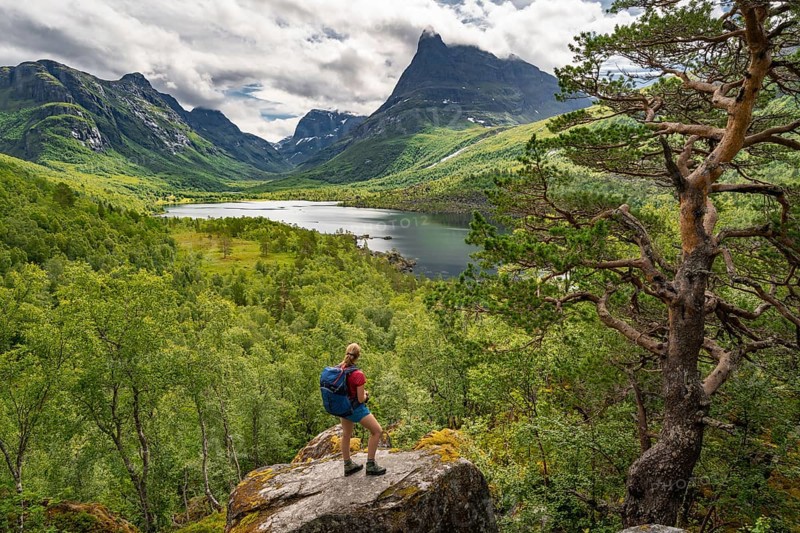 Hiker looking at high valley Innerdalen with lake Innerdalsvatna