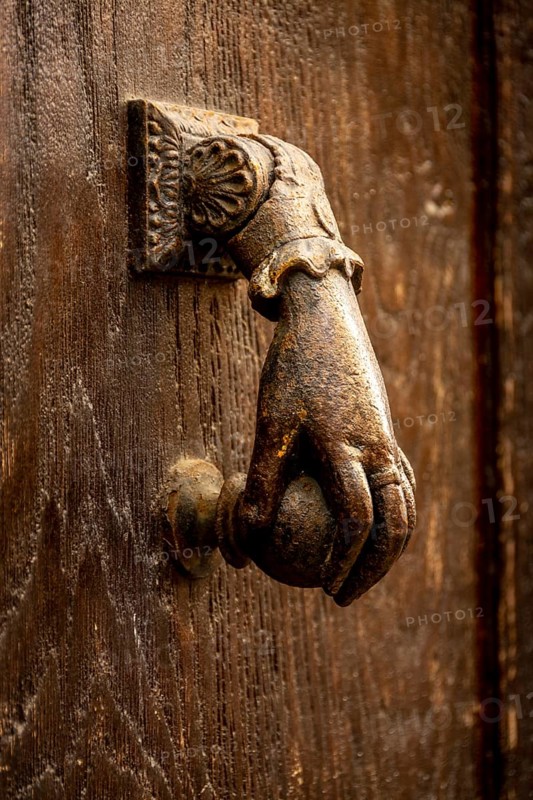 Knocker shaped like a hand on a wooden door