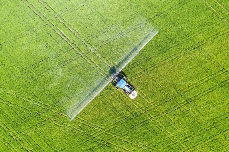 Tractor spraying fungicide onto the rice fields