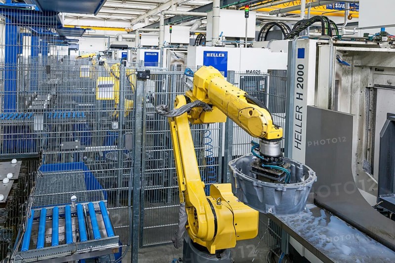 Industrial robot and car parts on a conveyor belt in a car parts factory