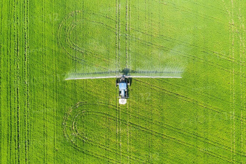 Tractor spraying fungicide onto the rice fields