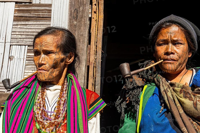 Chin women with spiderweb tattoo smoking a pipe