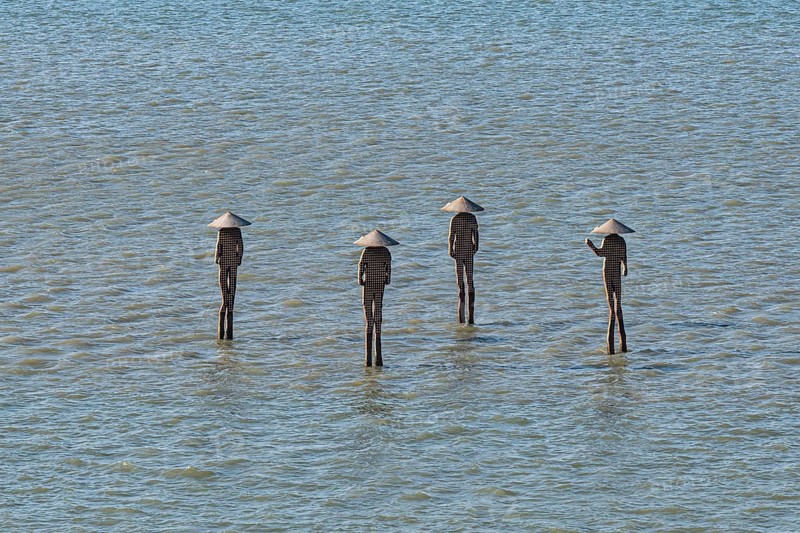 People statues standing in the ocean