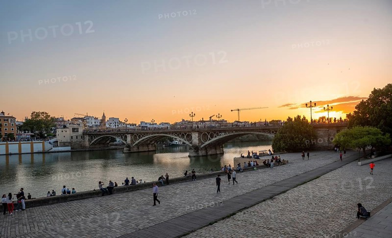 Waterfront Muelle de la sal at the river Rio Guadalquivir with bridge Puente de Triana