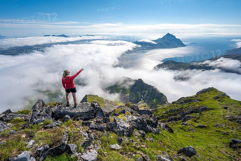 Hiker looking over mountain landscape in clouds